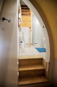 ein Torbogen, der zu einer Treppe in einem Raum führt in der Unterkunft Morgana in Casarano