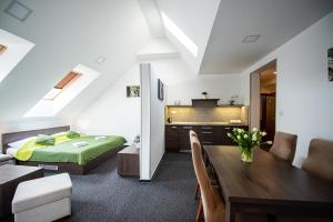 a bedroom with a bed and a dining room at Wellness Penzión Ferrata in Martin