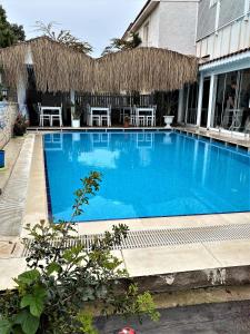 a large blue swimming pool with tables and chairs at Alacati Eldoris Butik Hotel in Alaçatı