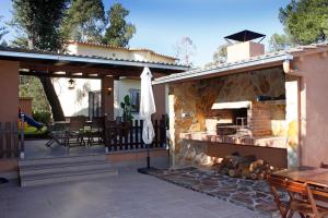 a patio with a grill and a table and chairs at Villadora in Santa Coloma de Farners