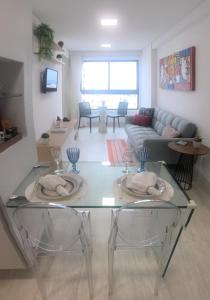 a living room with a glass table with two chairs at Lindo Ap 1102 Vista do Mar c Garagem in Recife