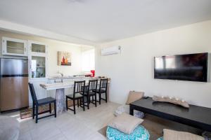 a living room with a kitchen and a bar at Serene by the Sea in Savaneta