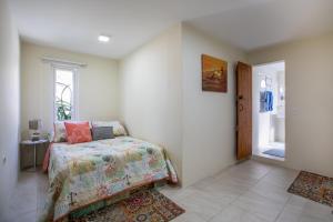 a bedroom with a bed and a window and a door at Serene by the Sea in Savaneta
