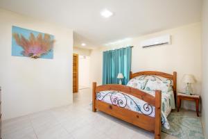 a bedroom with a wooden bed in a room at Serene by the Sea in Savaneta