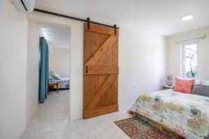 a bedroom with a sliding barn door and a bed at Serene by the Sea in Savaneta
