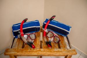 a pair of glasses sitting on top of a wooden bench at Serene by the Sea in Savaneta