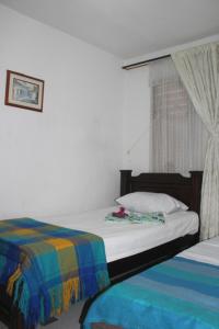 - une chambre avec 2 lits et une fenêtre dans l'établissement Hospedaje Primavera, à Medellín