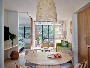 a living room with a table with fruit on a plate at Crystalbrook Byron in Byron Bay