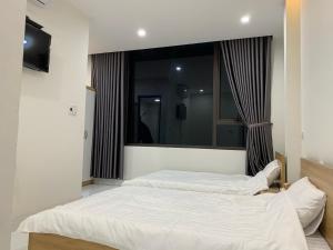 two beds in a bedroom with a large mirror at 58M Motel in Cao Bằng