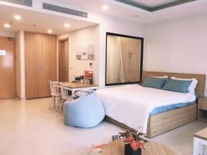 a bedroom with a large bed and a table at FLC SEA TOWER - 4 STUDIO 16 PAX SKY VIEW in Quy Nhon