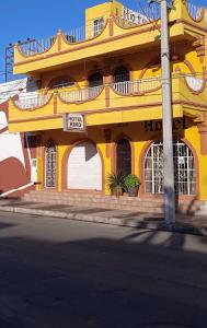 un edificio amarillo al lado de una calle en Hotel Kiko, en Mazatlán