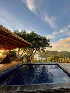 a swimming pool in a backyard with a fence at Elang Hillside Bamboo Villas in Labuan Bajo