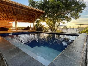 a swimming pool with a gazebo at Elang Hillside Bamboo Villas in Labuan Bajo