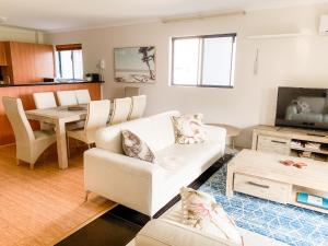 a living room with a couch and a table at Spacious Homely Apartment Close to Everything in Perth