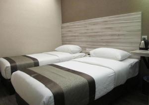 two beds in a hotel room next to each other at Hotel Austin Paradise - Taman Pulai Utama in Skudai