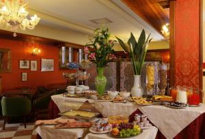 ein Buffet mit Speisen auf einem Tisch im Zimmer in der Unterkunft Hotel Castello in Venedig