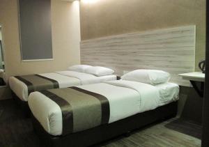 two beds sitting next to each other in a room at Hotel Austin Paradise - Taman Pulai Utama in Skudai