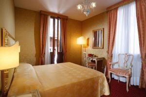 a hotel room with a bed and a table and chairs at Hotel Castello in Venice
