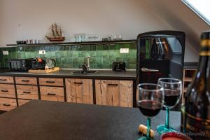 una cocina con nevera negra y 2 copas de vino en Eger Castle Hill Premium Apartments, en Eger