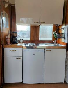 una pequeña cocina con armarios blancos y fregadero en Junamajoitus Tuuri Train Station, en Tuuri