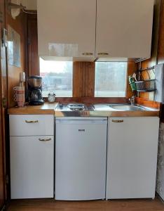 a small kitchen with white cabinets and a sink at Junamajoitus Tuuri Train Station in Tuuri +30 photos