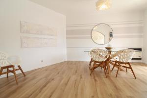 uma sala de jantar com uma mesa, cadeiras e um espelho em Rustic Beach House at the Cliff T3 | C218 em Porches