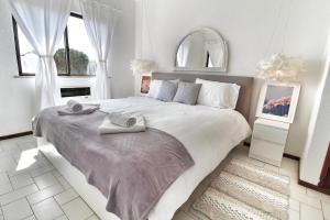 um quarto com uma cama grande com duas toalhas em Rustic Beach House at the Cliff T3 | C218 em Porches