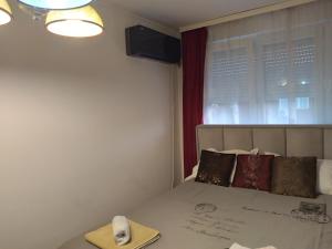 a bedroom with a bed and a window with a towel at Apartman CENTAR in Banja Luka
