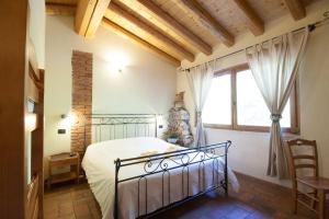 a bedroom with a bed and a large window at Agriturismo BioBiò in Vobarno