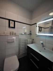 bagno bianco con lavandino e servizi igienici di Aal-6EG a Haffkrug