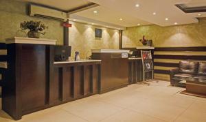 a bar in a restaurant with a leather chair at Treebo Savoury Sea Shell Residency in Bengaluru