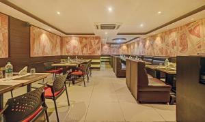 a restaurant with tables and chairs in a room at Treebo Savoury Sea Shell Residency in Bengaluru