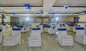a banquet hall with white and blue tables and chairs at Treebo Savoury Sea Shell Residency in Bengaluru