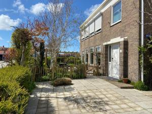 a brick house with a gate and a driveway at Welcome in - Vakantiewoning in het centrum met tuin en airco, Zoutelande in Zoutelande
