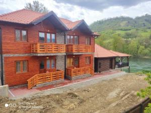 LjubovijaにあるApartmani ODMOR NA DRINIの大きなデッキと水を備えた木造家屋