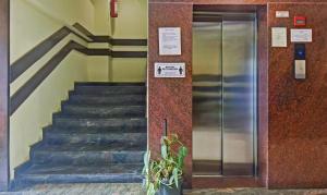 a metal elevator in a building with a staircase at Treebo Savoury Sea Shell Residency in Bengaluru
