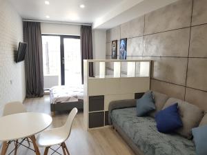 a living room with a couch and a bed and a table at Sunrise Arcadia Sky in Odesa