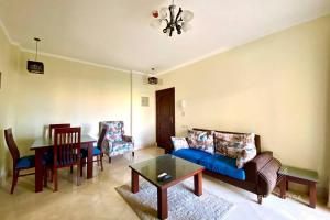 a living room with a blue couch and a table at Comfy apt by Sentido Marsa Alam in Marsa Alam City