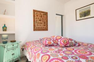コラレホにあるCasa Aguaのベッドルーム1室(カラフルな掛け布団、枕付)