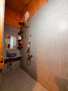 un baño con ducha y lavabo en Little Yen's Homestay, en Mèo Vạc