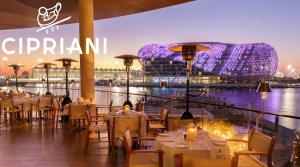 ein Restaurant mit Tischen und Stühlen und Blick auf ein Stadion in der Unterkunft Yas Island in Abu Dhabi