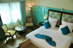a bedroom with a large bed with a blue headboard at The Reserve Boutique Hotel in Karachi