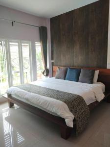 um quarto com uma cama grande e uma cabeceira em madeira em Muaan Resort em Suphan Buri