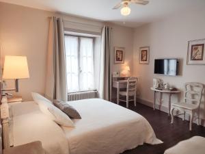 a bedroom with a bed and a desk and a television at Chambres d'Hotes Le 1900 in Val Couesnon