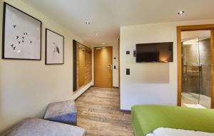 a bedroom with a bed and a television on the wall at Fuchs und Gretl in Saalbach-Hinterglemm