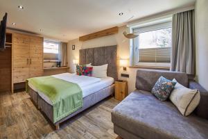 una camera da letto con un letto e un divano di Fuchs und Gretl a Saalbach Hinterglemm