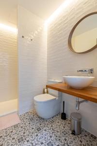a bathroom with a sink and a toilet and a mirror at Tu casa en Herrera el viejo in Seville