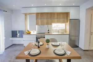 a kitchen and dining room with a wooden table at JOY C Deluxe in Iraklitsa
