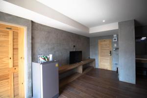 Pi MaiRabbit Hotel Phimai的客厅配有冰箱和电视