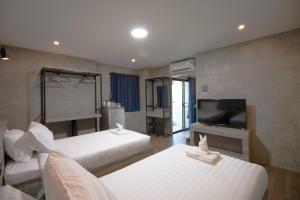 Pi MaiRabbit Hotel Phimai的一间有两张床和一台平板电视的酒店房间 更多37张照片